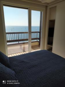 a bedroom with a bed and a view of the ocean at Espectaculares Vistas al mar Playa Malagueta in Málaga