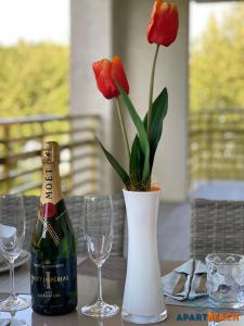Una botella de champán y un jarrón con flores en una mesa. en APARTBEACH NOVELTY FRENTE PLAYA y GRAN TERRAZA, en Salou