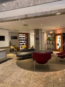 a lobby with couches and chairs and a fireplace at Apart-hotel, piscina, TV a cabo, academia in Joinville