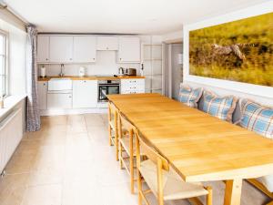 a kitchen with a wooden table and chairs at Gardeners Cottage in Chipping Norton