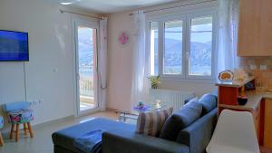 a living room with a blue couch and two windows at Blue Lagoon Luxury Apartment A2 in Argostoli