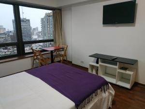 um quarto de hotel com uma cama, uma secretária e uma janela em Departamento en Apart hotel, Excelente ubicación en Microcentro em Buenos Aires