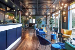 Un restaurante con sillas azules y un bar. en Sure Hotel by Best Western Calais Coquelles Tunnel s/ Manche, en Coquelles
