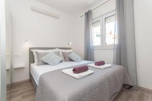 een slaapkamer met een bed met twee handdoeken erop bij Deluxe apartment White Angel in Duće