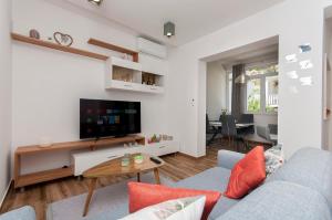 een woonkamer met een blauwe bank en een tv bij Deluxe apartment White Angel in Duće