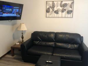 a black leather couch in a living room with a flat screen tv at Rockwood Resort Motel in Lake Ozark