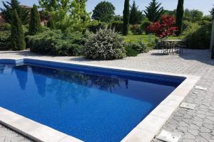 a swimming pool with blue water in a yard at Logement, classé 3 étoiles, de 42 m2 tout confort avec piscine pour un couple in Cahuzac-sur-Vère