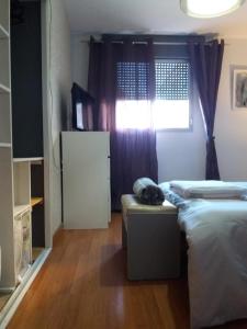 a small room with two beds and a window at near airport in Las Lagunas