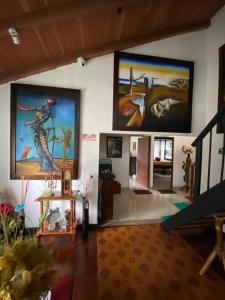 a living room with two large paintings on the wall at Alojamiento Campestre LA PASTORA in Salento