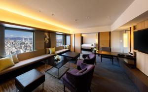 a living room filled with furniture and a large window at Hotel Nikko Osaka in Osaka