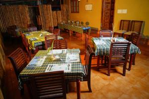 a dining room with tables and chairs with checkered tablecloths at Hiliya Resort in Kenichira