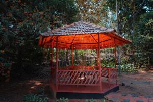 a red gazebo with a canopy in a garden at Hiliya Resort in Kenichira