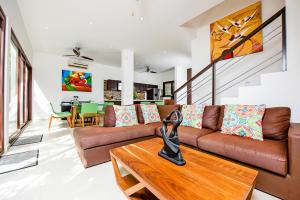 un soggiorno con divano marrone e tavolo di Tao Ocean Luxury Home Akumal ad Akumal