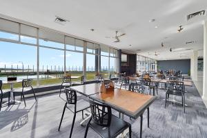 a restaurant with tables and chairs and large windows at Scamander Beach Resort in Scamander