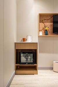 a microwave in a cabinet in a room at Shanghai JOYFUL YARD Hotel-Free shuttle bus to Pudong Airport and Disneyland in Shanghai