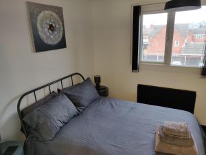 a bedroom with a bed and a window at Riverside Park Penthouse Apartment In St Neots in Saint Neots