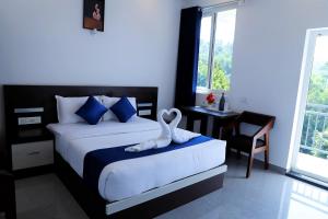- une chambre avec un lit et une serviette de cygne dans l'établissement Casillda Munnar, à Munnar