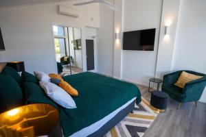 een slaapkamer met een groen bed en een bank bij Dacha on Maggie No#1 OPULENT AND LUXURIOUS in Nelly Bay