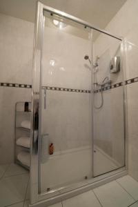La salle de bains est pourvue d'une douche avec une porte en verre. dans l'établissement The Burnside Hotel, à Glasgow