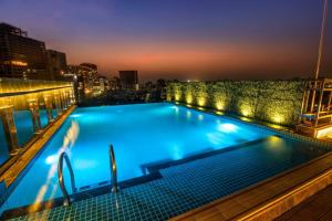a swimming pool on the roof of a building at night at The Raintree Dhaka - A Luxury collection Hotel in Dhaka