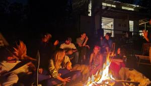 un grupo de personas sentadas alrededor de un fuego en Rancho Reencuentro Eco Hotel & Cabalgatas, en Valle de Bravo
