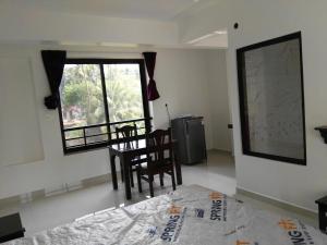 a room with a table and chairs and a window at Hotel Wave Morjim in Morjim