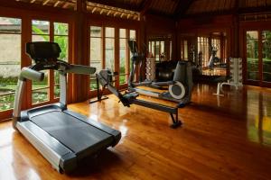 a gym with two treadmills and exercise bikes at Amandari in Ubud