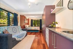 a kitchen and living room with a couch and a sink at Elevated Tropical House in Casuarina