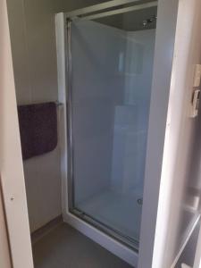 W łazience znajduje się prysznic ze szklanymi drzwiami. w obiekcie Adventureland Cabins w mieście Darawank