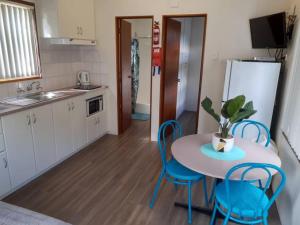 a kitchen with a table and chairs and a refrigerator at Adventureland Cabins in Darawank