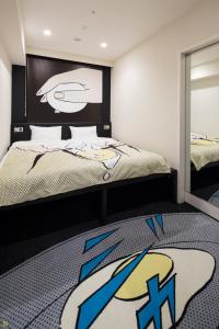 um quarto com uma cama com uma fotografia de futebol na parede em HOTEL TAVINOS Hamamatsucho em Tóquio