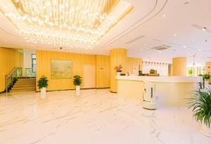 a large lobby with a reception desk and a chandelier at Shanghai JOYFUL YARD Hotel-Free shuttle bus from Pudong Airport and Disneylan in Shanghai