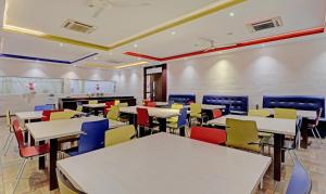 an empty classroom with tables and colorful chairs at Treebo Trend Astor HSR Layout in Bangalore