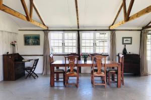 uma sala de jantar com uma mesa de madeira e cadeiras em Dream the Days away by Yourhost The Rustic Barn Nanyuki Kenya em Nanyuki
