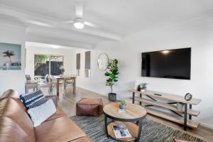 a living room with a couch and a flat screen tv at Lennox Belle in Lennox Head