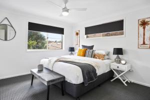 a white bedroom with a large bed and a window at Lennox Belle in Lennox Head