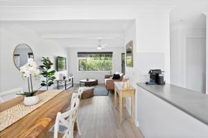 a kitchen and living room with a table and a living room at Lennox Belle in Lennox Head