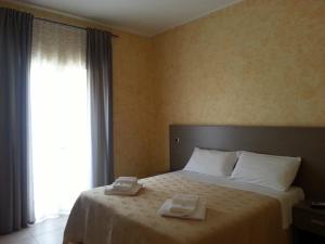 een slaapkamer met een bed met twee handdoeken erop bij B&B Casa Venezia in Bernalda