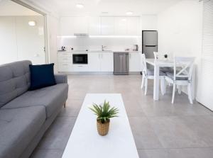 a living room and kitchen with a couch and a table at Noosa River Palms in Noosaville