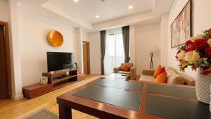 a living room with a couch and a tv at Pacific Place Serviced Apartment in Hanoi