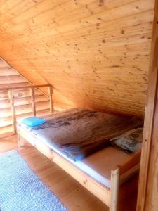 a bunk bed in a cabin with a wooden ceiling at Oksa Puhkemaja in Võru