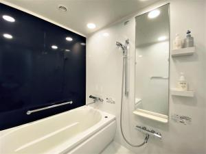 een badkamer met een douche, een bad en een wastafel bij Hiroshima Tokyu REI Hotel in Hiroshima