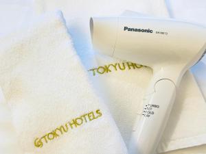 a white hair dryer sitting next to a towel at Hiroshima Tokyu REI Hotel in Hiroshima