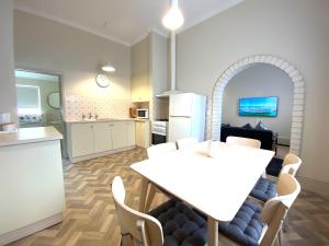 a kitchen and dining room with a white table and chairs at Clifton Motel & Grittleton Lodge in Bunbury