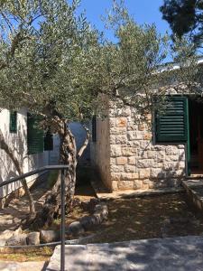 een stenen gebouw met een boom ervoor bij Holiday home Pavarotti in Supetar