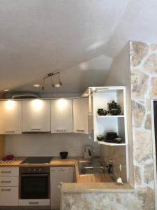 een keuken met witte kasten en een wastafel bij Holiday home Pavarotti in Supetar