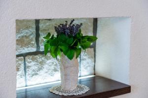a vase with purple flowers sitting on a table next to a window at Apartment Maru Prestige in Dubrovnik