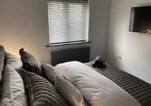 a bed sitting in a room with a window at Beautiful modern cosy central apartment / sleeps 4 in Reading