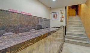 a lobby with a long counter and a staircase at Itsy By Treebo - Southend in Chandīgarh