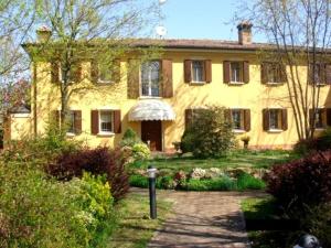 a large yellow house with a driveway in front of it at La Corte Del Cavaliere Bed & Breakfast in Calderara di Reno